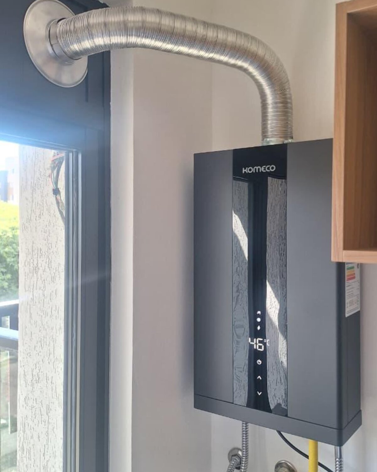 Aquecedor a gás Komeco instalado em área de serviço